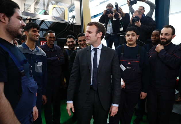 Emmanuel Macron rencontre de jeunes réfugiés sur un site d'apprentissage de la Deutsche Bahn, le 10 janvier 2017, à Berlin.