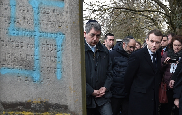 Le président Emmanuel Macron regarde les tombes profanées au cimetière de Quatzenheim, le 19 février 2019 dans le Bas-Rhin