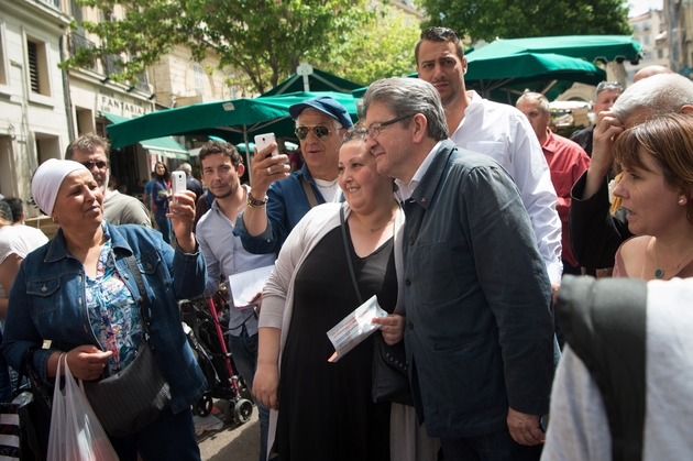 Jean-Luc Melenchon (C) se prête volontiers aux selfies avec les commerçants et les passants, qui s'avancent pour voir le candidat à Marseille, le 18 mai 2017