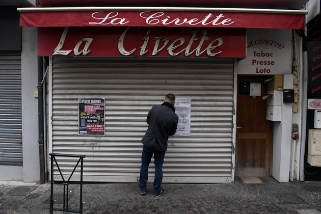 Un commerce, rideaux baissés, lors d'une journée 