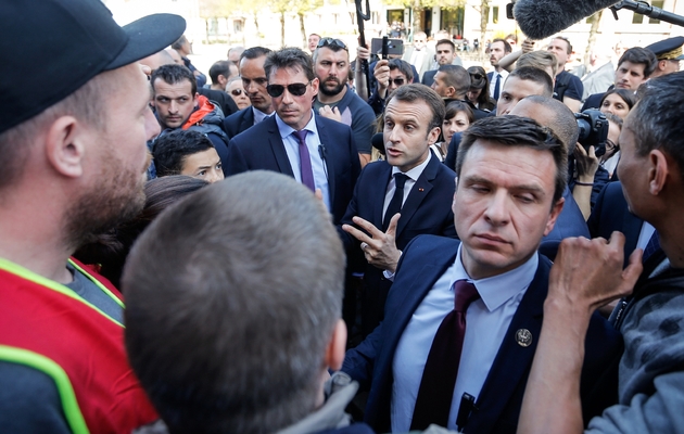 Emmanuel Macron (C) discute avec des manifestants opposés à ses réformes à Saint-Dié-des-Vosges, le 18 avril 2018