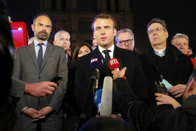 Le Premier ministre Edouard Philippe (G) et le président Emmanuel Macron (C) au pied de Notre Dame après l'incendie qui a ravagé la cathédrale, le 15 avril 2019 à Paris 