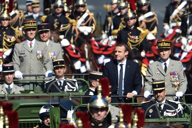Le président Emmanuel Macron (c) et le général Pierre de Villiers,chef d'état-major des forces armées, remonte les Champs-Elysées à bord d'un véhicule militaire, lors du défilé du 14 juillet 2017 à Paris 