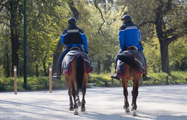 Des Gardes républicains à cheval patrouillent dans le Bois de Vincennes, à la lisière de Paris, dont des parties sont interdites d'accès, le 2 avril 2020