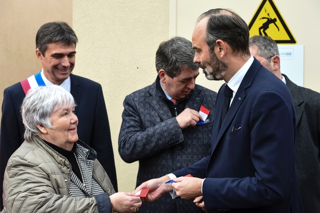 Le Premier ministre Edouard Philippe tend un drapeau français à la ministre de la Cohésion des Territoires, sous le regard du maire de Girancourt Jacqueline Gourault, Yannick Villemin