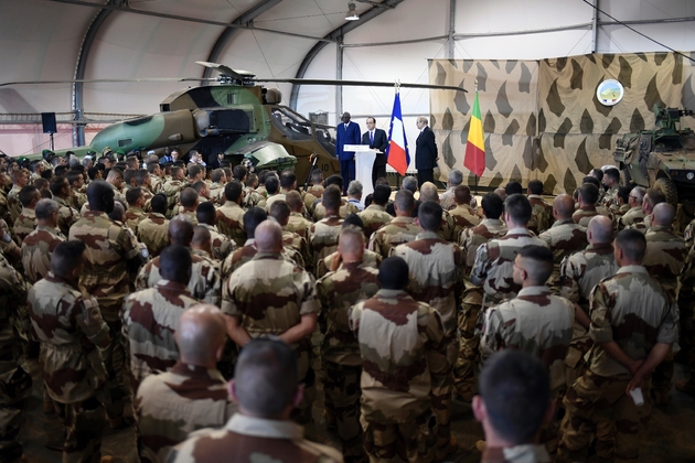 François Hollande (C), le Premier ministre malien Modibo Keita (G) et le ministre de la Défense française Jean-Yves Le Drian (D), face aux troupes de l'opération Barkhane à Gao, dans le nord du Mali, le 13 janvier 2017