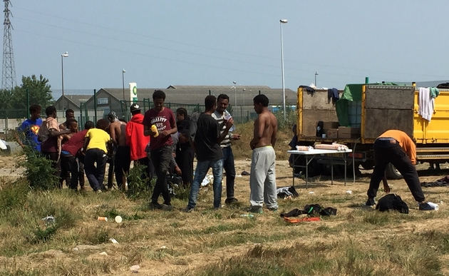 Des migrants font leur toilette à Calais le 21 juin 2017