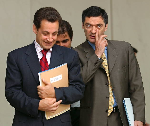 Le ministre de l'Intérieur Nicolas Sarkozy (g) et le ministre délégué aux Liberté locales Patrick Devedjian à la sortie de l'Elysée en septembre 2002 à Paris