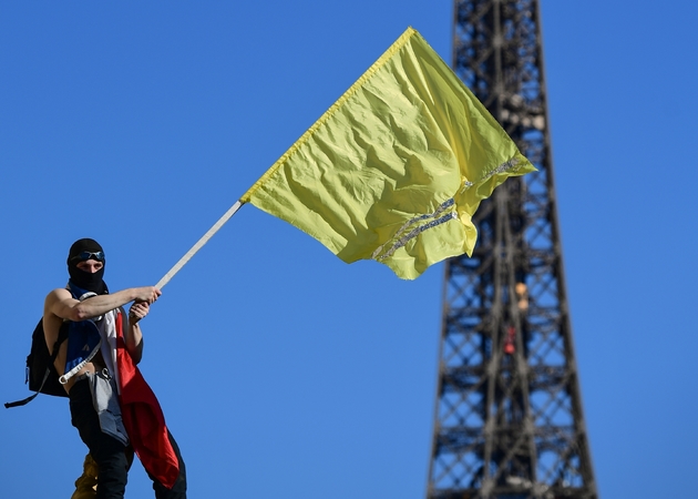 Un manifestant agite un drapeau jaune lors du vingtième samedi consécutif d'action des 