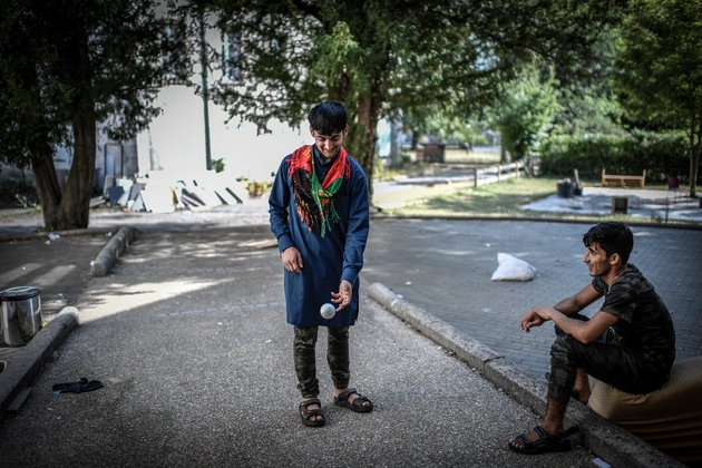 Des migrants afghans échangent dans la cour de leur centre d'hébergement de Forges-les-Bains (région parisienne) le 28 août 2018, peu avant la fermeture du lieu 