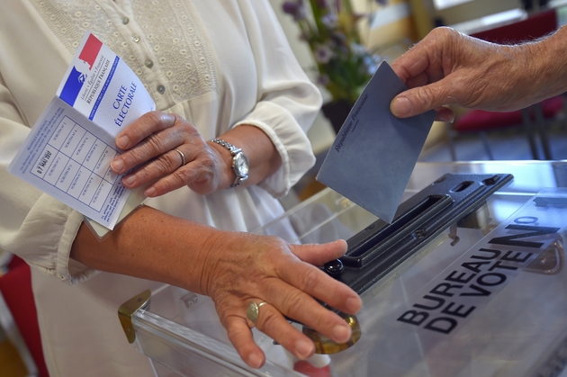 Un homme glisse son bulletin de vote dans l'urne d'un bureau de vote de Vertou (Loire-Atlantique) dans l'Ouest de la France, le 11 juin 2017