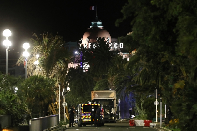 Des policiers près d'un camion qui a roulé dans la foule le 14 juillet 2016 à Nice, faisant 86 morts