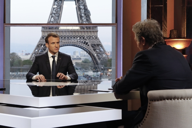Le président Emmanuel Macron (c) lors d'un entretien à la télévision avec les journalistes de RMC-BFM Jean-Jacques Bourdin  (d) et Mediapart, Edwy Plenel (g), au palais de Chaillot, le 15 avril 2018 à Paris