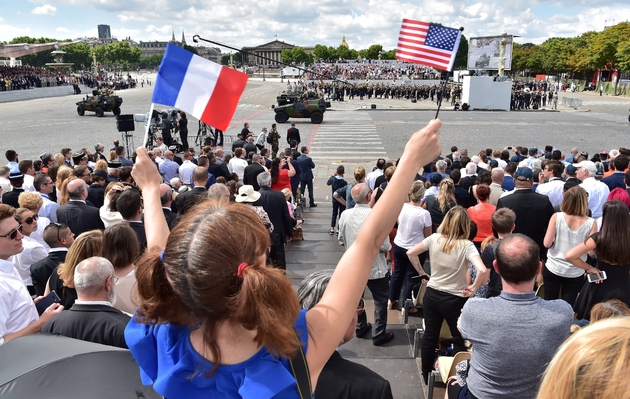 Une fille agite les drapeaux français et américain lors du défilé du 14 juillet 2017 sur les Champs-Elysées à Paris
