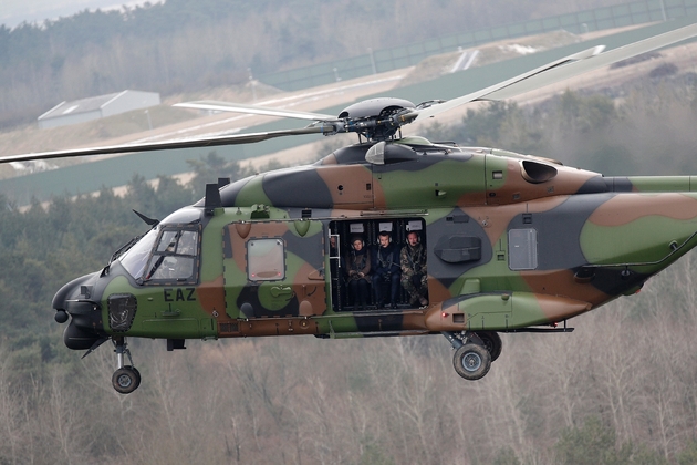 Le président Emmanuel Macron (c), la ministre de la Défense Florence Parly et le chef d'état-major de l'armée de terre, le général Jean-Pierre Bosser, à bord d'un hélicoptère NH90, survolent le camp militaire de Suippes, près de Reims, lors d'un exercice