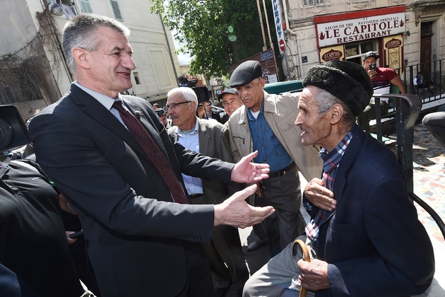 Le député centriste et candidat à la présidentielle Jean Lassalle (g), salue un homme dans la rue lors d'un déplacement de campagne à Marseille, le 12 avril 2017