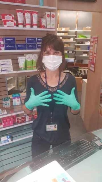 Femme avec des gants et un masque dans une pharmacie