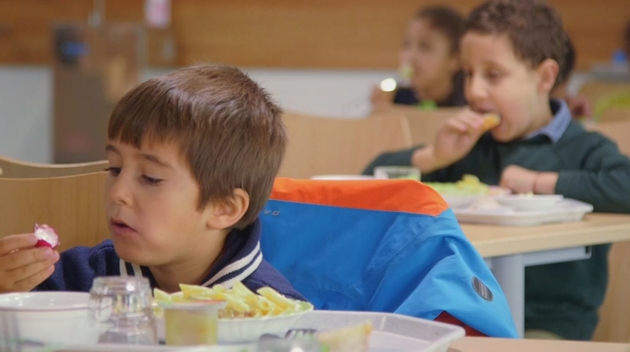 Un enfant prenant son repas à la cantine scolaire